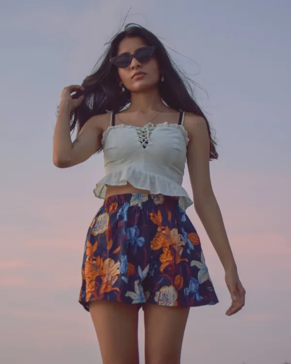 Woman in sunglasses and Whats Down navy floral printed boxers at the beach at sunset standing