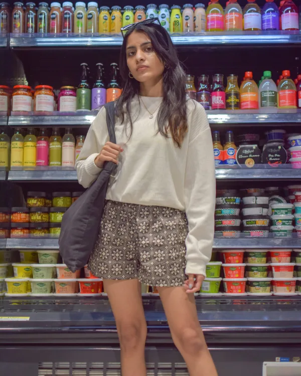 Woman in a cream sweater and Whats Down grey printed boxers in a convenience store