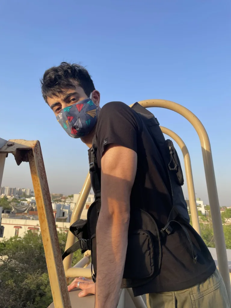 Man in a Whats Down printed face mask on a rooftop at sunset