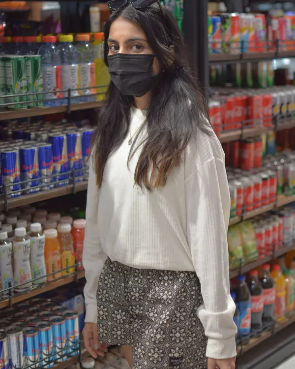 Woman in a cream sweater and Whats Down grey printed boxers in a supermarket in the snack aisle