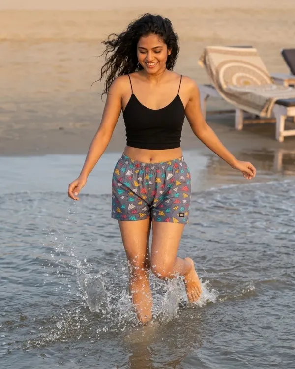 Woman in a black top and Whats Down printed cotton boxers running through the waves
