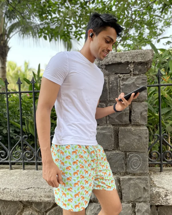 Man in a tee and Whats Down printed cotton boxers smiling by a stone wall