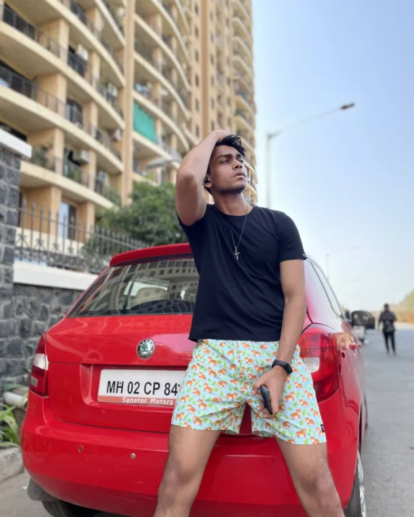 Man in a tee and Whats Down printed cotton boxers leaning on a red car in the city