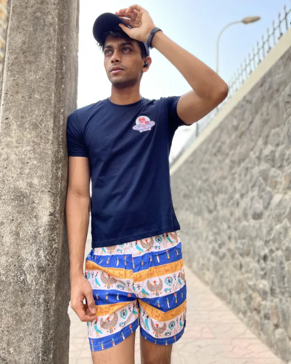 Man in a tee and Whats Down printed cotton boxers adjusting his cap in the sun