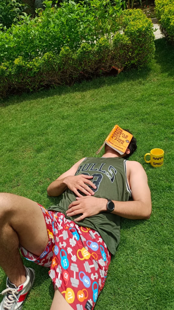 Man napping on the lawn in Whats Down red printed boxers with a book over his face