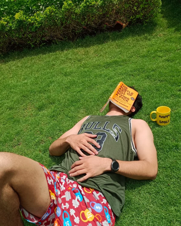 Man napping on the lawn in Whats Down red printed boxers with a book over his face