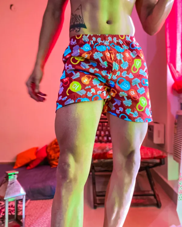 Man in Whats Down navy pop-print boxers in a neon-lit room standing