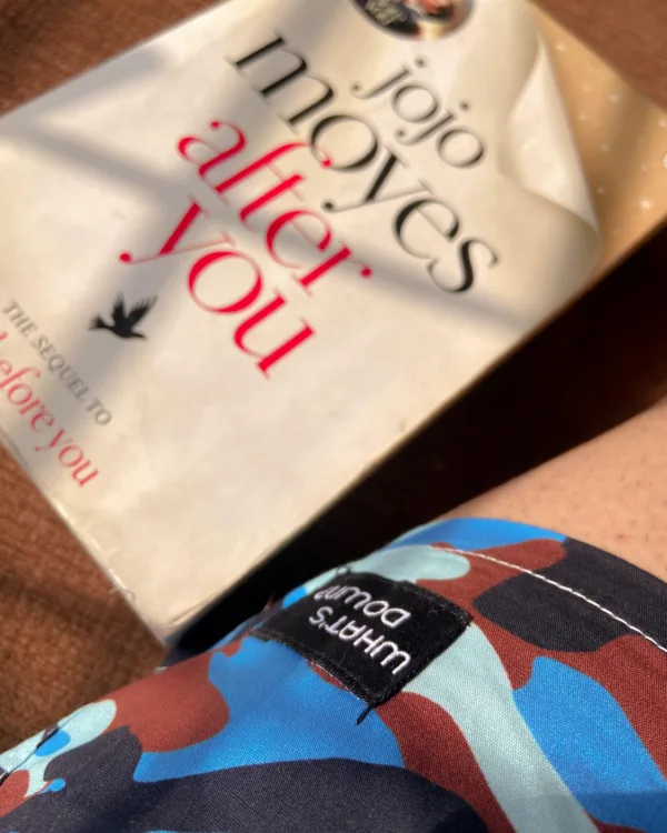 Man reading on the bed in Whats Down Blue Camo printed boxers. Photo 1