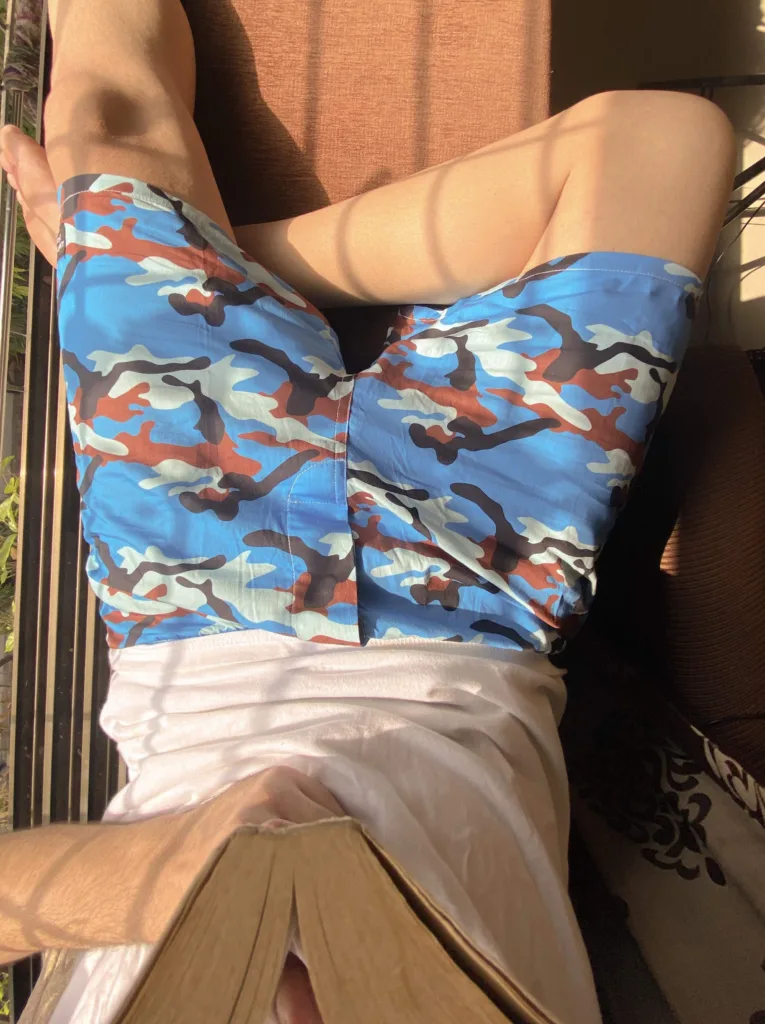 Man reading on the bed in Whats Down Blue Camo printed boxers. Photo 2