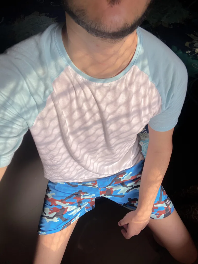 Man reading on the bed in Whats Down Blue Camo printed boxers. Photo 3