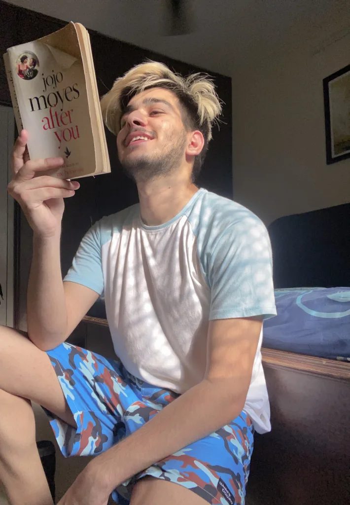 Man reading on the bed in Whats Down Blue Camo printed boxers. Photo 6
