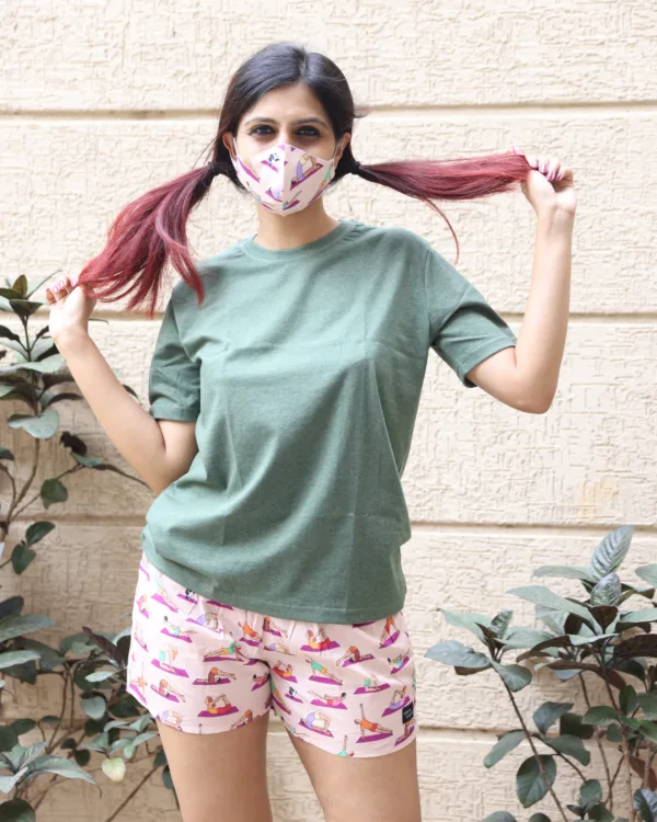 Women in pastel tees and Whats Down pink and red printed boxers on a plant-filled terrace hand on hip