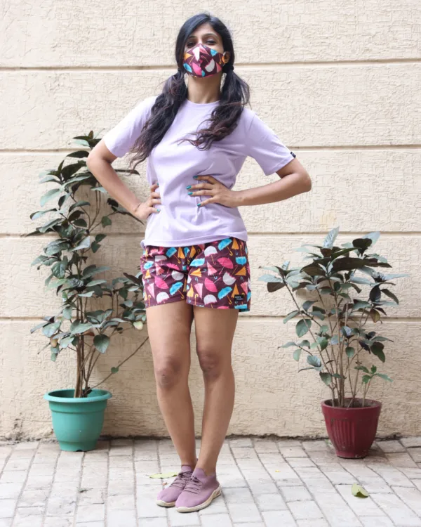 Women in pastel tees and Whats Down pink and red printed boxers on a plant-filled terrace by the planters