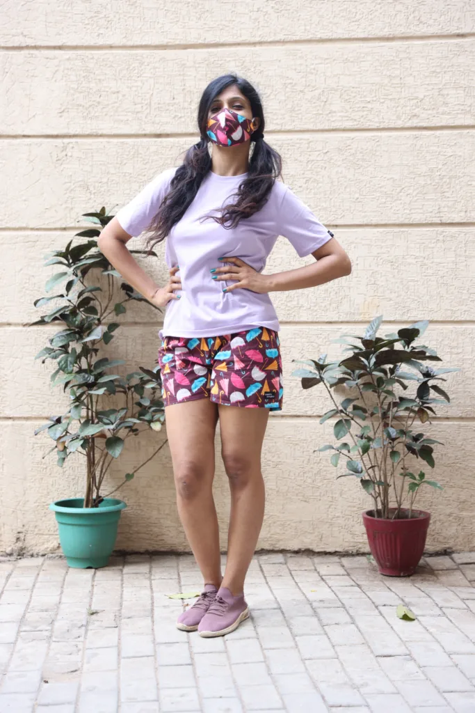 Women in pastel tees and Whats Down pink and red printed boxers on a plant-filled terrace by the planters