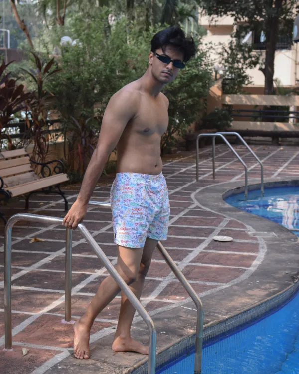 Man in Whats Down white printed boxers by the pool on the steps